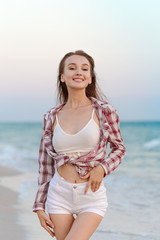 Fototapeta na wymiar Happy carefree woman on the beach enjoying summer
