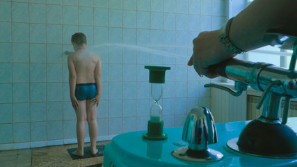 Boy having high pressure massage with Sharko shower. Water treatment