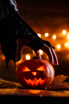 Image of halloween background with pumpkin and witch hand
