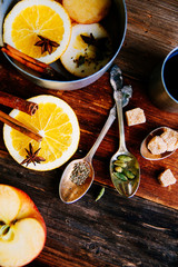 Mulled wine hot drink with citrus, apple and spices in aluminum casserole and Fir branch on concrete background