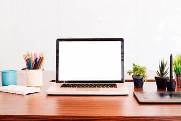 Laptop computer on workspace and other office gadget, empty screen mockup.