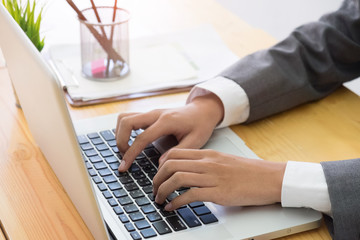 Business using laptop computer hand typing keyboard on business office.
