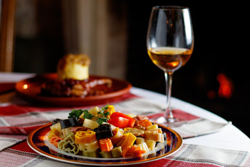 Heart shaped red and white pasta with artichokes, pine nuts, capers and parsley in a bowl
