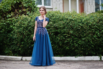 Fototapeta premium Portrait of a beautiful and gentle girl in elegant gown posing outdoor.
