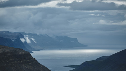 Fototapeta na wymiar the austere Icelandic landscape with the mountains and the fjords and the ocean in the background