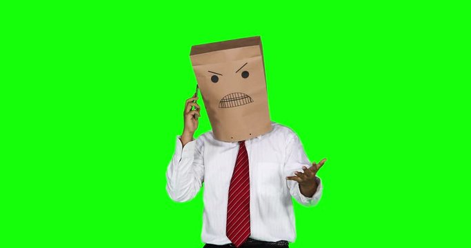 Angry anonymous businessman with a paper bag on his head, talking on cellphone while scolding someone. Shot in 4k resolution