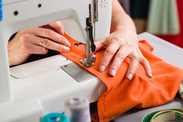 Sewing workshop. Stapling the material on the machine.