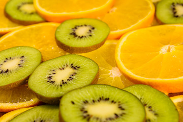Fototapeta na wymiar Background of the kiwi and orange fruits. Selective focus