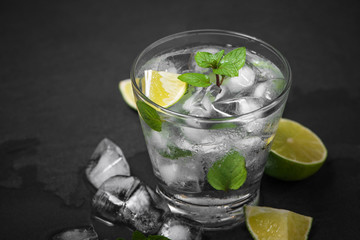 Mojito cocktail with lime and mint in glass on a grey stone background