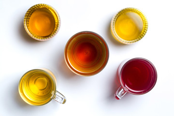 Various herbal tea in glass cups on white