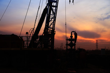 the silhouette of oilfield derrick