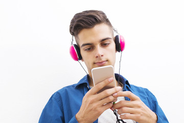 young modern teenager with phone and headphones listening to music