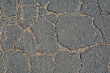 Grey cracked asphalt background.