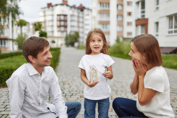 Happy family in front of new apartment building
