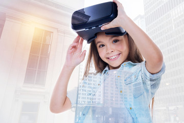 Cute little girl removing VR headset