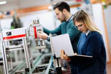 Two young handsome engineers working on electronics components
