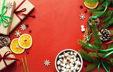 A cup of hot coffee with marshmallow Fir branches Chinks New Year gifts Orange slices Snowflakes...