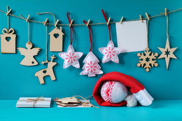 Christmas and New Year decorations made of plywood and felt hanging on the rope. Christmas and New Year decorations with card on a light blue wooden background.