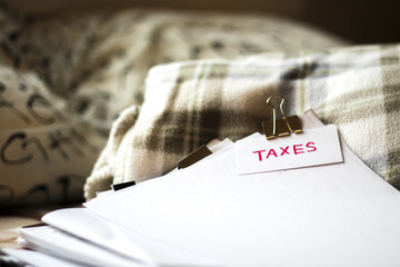 Taxes; Stack of Documents. Working or Studying at Bedroom.