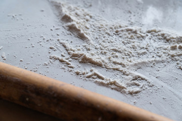 sifted flour on the table, a rolling pin