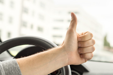 Happy driver showing thumbs up in car. Satisfied with new car or no traffic. Passed driving school...