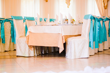 the restaurant is decorated with decorators and florists . The bows on the chairs , flowers on the tables