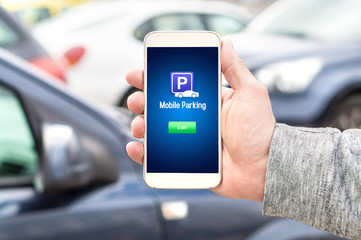 Mobile parking app on smartphone screen facing camera. Man holding smart phone with car park application in hand. Internet payment online with modern device.