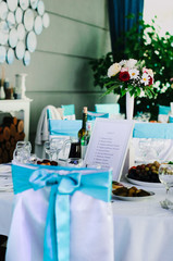 the restaurant is decorated with decorators and florists . The bows on the chairs , flowers on the tables