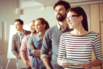 Fototapeta premium Joyful positive people standing behind each other