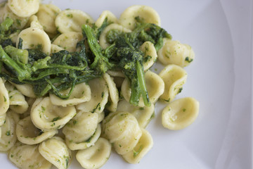 Orecchiette con le cime di rapa fatte in casa in un piatto rettangolare. Cibo pugliese.