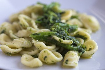Orecchiette con le cime di rapa fatte in casa in un piatto rettangolare. Cibo pugliese.