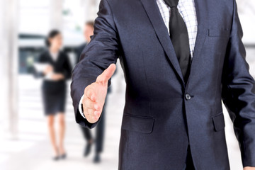 Businessman offering handshake on group of business  background