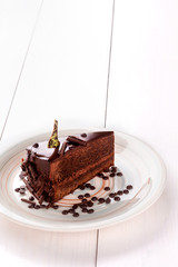 Small cake with different stuffing on a white plate. White wooden table.