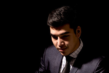 Obraz premium Portrait of young businessman on dark background