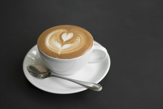 closeup coffee latte art cup on black table