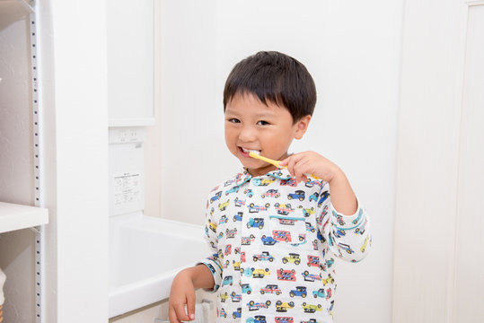 パジャマで歯磨きする男の子