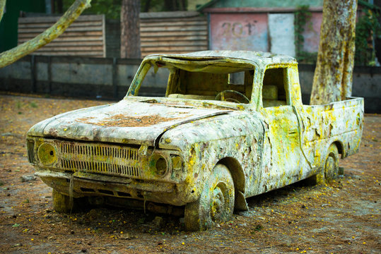 An old rusty car in paint from paintball.