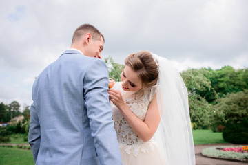 Bride pins boutonniere to groom's jacket