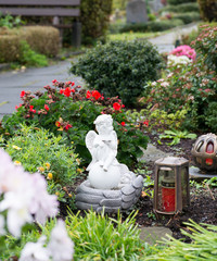 Kleiner Engel auf einer Kugel mit Grablampen