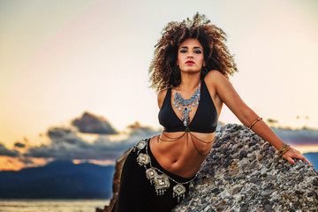 ragazza danza sugli scogli al tramonto in riva al mare