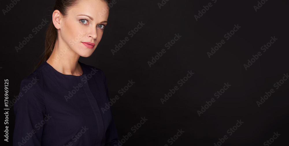 Wall mural Beautiful woman over black background with copy space