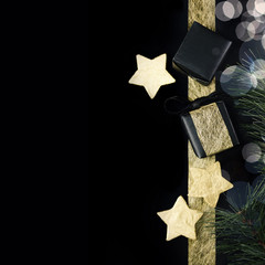 Black and gold christmas gifts with foil stars on dark background. Holiday, new year concept. Text space