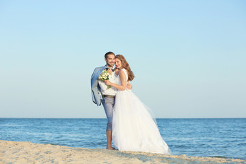 Fototapeta na wymiar Happy wedding couple on sea beach
