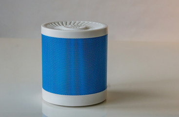 Close-up of a portable speaker on a white background connecting to a smartphone. Concept Technology.