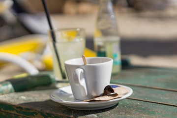 Nostalgia for the passing summer. Close-up of a cup of aromatic coffee on the beach. Bockeh background. Concept, relaxation on the beach.