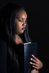 Young Girl Holding Bible Close To Her Heart