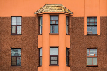 Several windows and bay window in a row on facade of urban apartment building front view, St. Petersburg, Russia