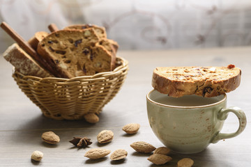 Traditional Italian biscotti Almond Cantuccini in a basket decorated with nuts on wooden table