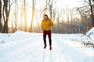 Man in red jogging pants and yellow jacket hiking in park