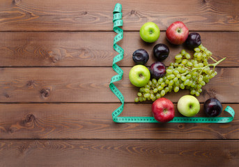 Diet concept with measuring tape and fresh fruits
